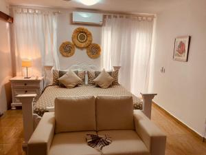 a bedroom with a bed with a couch and a mirror at Villa Dylan Samana, Luxury 3Br with pool in Santa Bárbara de Samaná +46 photos