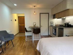 a bedroom with a bed and a kitchen with a counter at Next Door in Punta Arenas