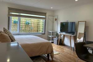 a bedroom with a bed and a flat screen tv at Next Door in Punta Arenas