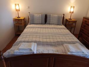 a bedroom with a bed with two lamps on two tables at Carneiro Country Houses Casa das Batatas in Amarante
