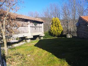 an old barn in a field next to a yard at Carneiro Country Houses Casa das Batatas in Amarante