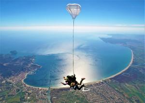 a teddy bear hanging from a parachute over the water at Sol playa piscina in Empuriabrava