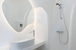 a white bathroom with a sink and a mirror at Nevma Suites in Firostefani +33 photos