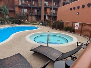 a swimming pool in a building with chairs around it at Lakeshore Villa Estates in Osoyoos