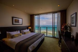 a bedroom with a bed with a view of the ocean at Grand Papua Hotel in Port Moresby