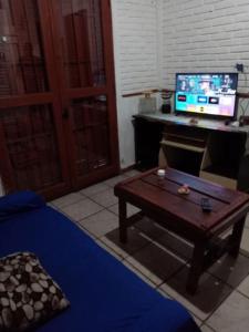 a living room with a table and a desk with a computer at Isabella in Xuí