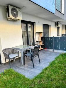 a patio with a table and two chairs and a fan at Urban Haven Apartment in Oradea