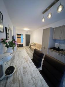 a kitchen and living room with a table and a couch at Urban Haven Apartment in Oradea +1 photo