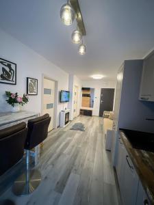 a living room with white walls and wooden floors at Urban Haven Apartment in Oradea
