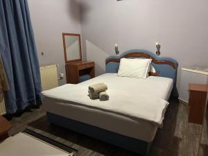 a bedroom with a bed with a teddy bear on it at Restoran Gurman in Kraljevo