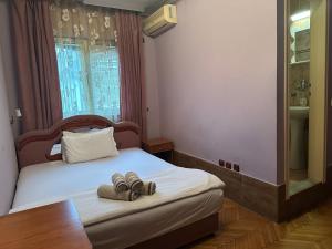 a bedroom with a bed with two shoes on it at Restoran Gurman in Kraljevo +6 photos