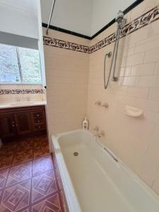 a bathroom with a white tub and a shower at Genesta House in Cowes +10 photos