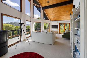 a living room with a lot of windows at The Black Chalet in Whitianga