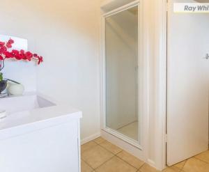 a white cabinet with a glass door in a kitchen at Argo Sands, Steps From The Beach! in Rosebud