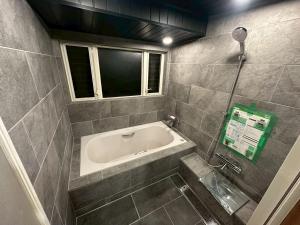 a bathroom with a tub and a window at A luxurious accommodation experience surrounded by nature in Okazaki