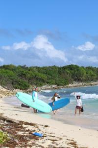 a group of people standing on the beach with surfboards at Casa Samay in Cozumel
