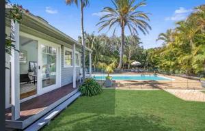 a house with a swimming pool and a yard at Tosca Elegant Merewether Beach House with Pool in Merewether
