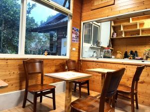 a dining room with two tables and chairs and a window at 十畝田山莊 in Chishang +66 photos