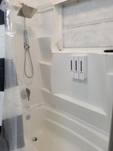 a white bathroom with a tub and a shower at Charming Private Studio,Full Amenities, Great Location in Orlando +3 photos