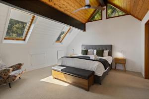 a bedroom with a bed and a ceiling with skylights at The Black Chalet in Whitianga
