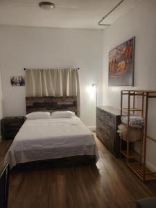 a bedroom with a bed and a dresser in it at Charming Private Studio,Full Amenities, Great Location in Orlando
