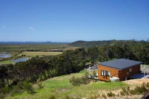 a small house on top of a hill at Estuary Escape in Kaingaroa
