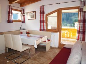 ein Wohnzimmer mit einem Tisch, einem Sofa und einem Fenster in der Unterkunft Ferienwohnungen Eiter Fridolin in Zaunhof