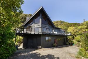 a house with a balcony and a garage at The Black Chalet in Whitianga