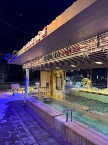 a swimming pool in front of a building at night at Yunokawa Onsen KOMOREBISO in Hakodate
