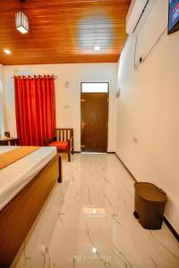 a bedroom with a bed and a red curtain at Eden Udawalawe in Udawalawe