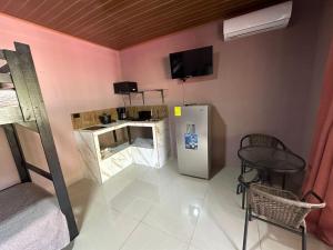 a room with a refrigerator and a tv on the wall at Cabinas Hukats Secret Jungle in Puerto Viejo