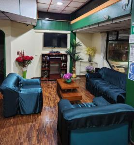 a living room with couches and a flat screen tv at Hotel Piquellan in Quito
