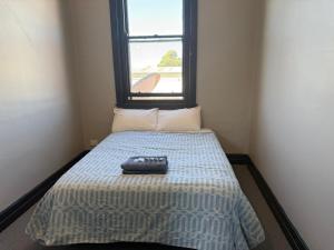 a bed in a small room with a window at Golden Age Hotel in Beaufort