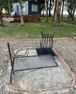 a metal object sitting on the ground in a park at Cabañas El Calabrés in Tacuarembó