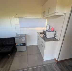 a small kitchen with a counter and a microwave at Cabañas El Calabrés in Tacuarembó