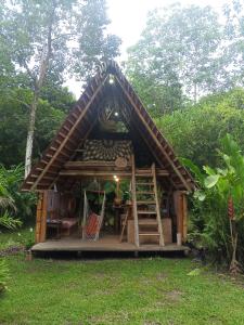 a small house with a staircase in a yard at Cabaña Bugambilla in Macas