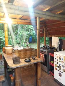 an outdoor kitchen with a table and a stove at Cabaña Bugambilla in Macas