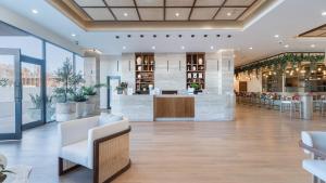 eine Lobby mit einer Bar mit weißen Stühlen und Tischen in der Unterkunft Encanto de Cortes in Playa Encanto