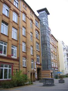 ein großes Backsteingebäude mit einem Glasturm daneben in der Unterkunft Hotel Transit Loft in Berlin