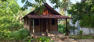 a small building with a roof on a yard at Alam Kita in Karimunjawa