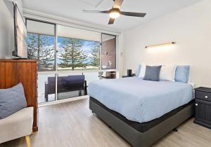 a bedroom with a bed and a large window at Reddall Waterside Stay in Lake Illawarra