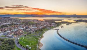 an aerial view of a town next to the water at Reddall Waterside Stay in Lake Illawarra +22 photos