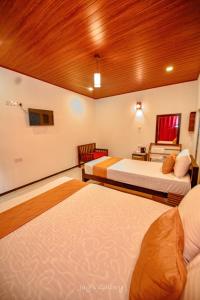 a hotel room with two beds and a table at Eden Udawalawe in Udawalawe