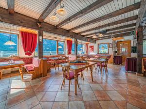 a restaurant with tables and chairs and windows at Falkenstein in Krimml