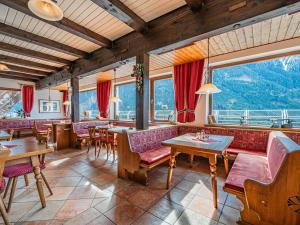 a restaurant with tables and chairs and large windows at Falkenstein in Krimml