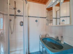 a bathroom with a blue sink and a shower at Falkenstein in Krimml