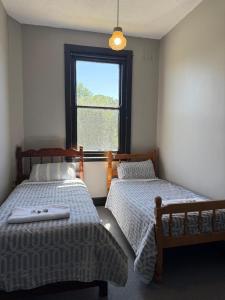 two beds in a room with a window at Golden Age Hotel in Beaufort