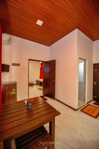 a living room with a table and a wooden ceiling at Eden Udawalawe in Udawalawe