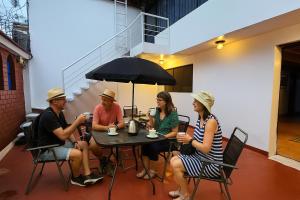 a group of people sitting at a table under an umbrella at Casa Independiente cerca al Centro en Segundo Piso - Los Profesionales in Cusco