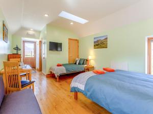 a bedroom with a blue bed and a desk and a bed at Quinag Studio Apartment - Uk49098 in Inchnadamph